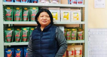Tshewang Dem standing in front of packaged food products