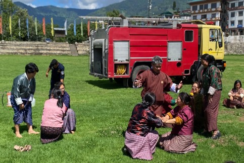 Yang training local female local leaders on fire safety and casualty lifting techniques.